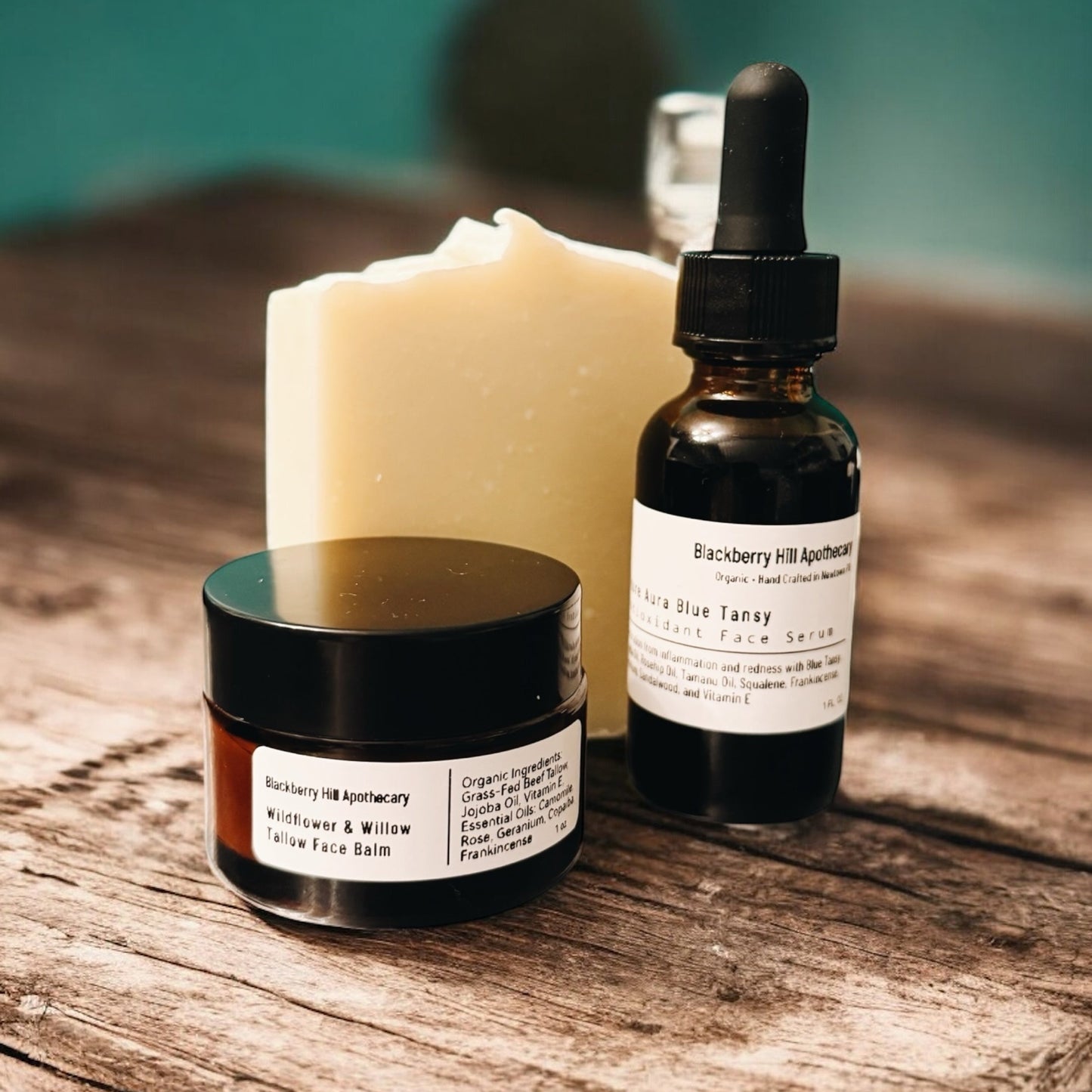 Skincare products including a jar, bottle with dropper, and candle on a wooden surface.